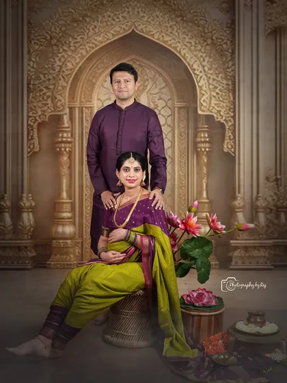 A regal studio portrait of a couple in matching purple traditional outfits, creating a coordinated and elegant look.