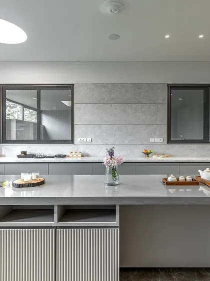 The island in Niketa Lalit Patel's kitchen features open shelving and a unique ribbed texture on the drawer fronts, adding a subtle decorative detail to the minimalist design.