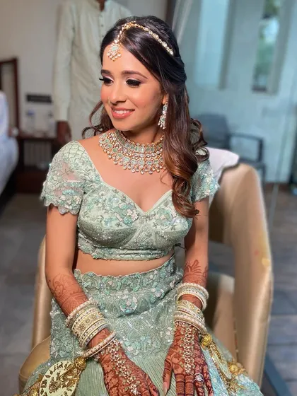 A seated portrait of Aashna, looking elegant and happy before her ceremony. The makeup is flawless even in natural light.