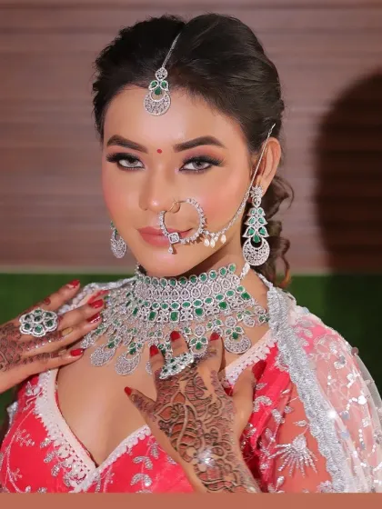 A beautiful bridal transformation. The final look features a stunning diamond and emerald jewelry set, paired with soft, glowing makeup.