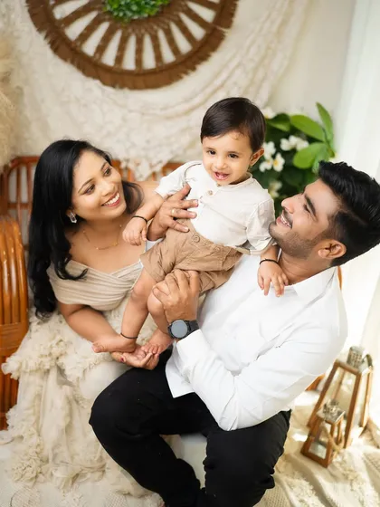 A beautiful family portrait from a boho-themed studio session. The parents' adoring gaze at their son captures a moment of pure, shared happiness.