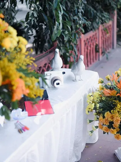 The full view of the Polaroid station, styled with large floral arrangements to make it an attractive and inviting corner for guests.
