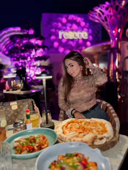 Posing with a delicious pizza at Resaca Delhi, capturing the fun and trendy atmosphere of the place.