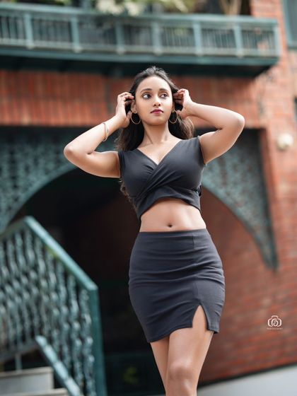 A three-quarter portrait against a brick wall, with the model looking off to the side. The warm tones of the brick and the urban setting create a cool, downtown vibe.