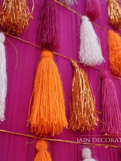 A close-up of the tassel wall, showing the texture and vibrant colors. This simple yet effective decor element adds a huge amount of visual interest and fun to the event.