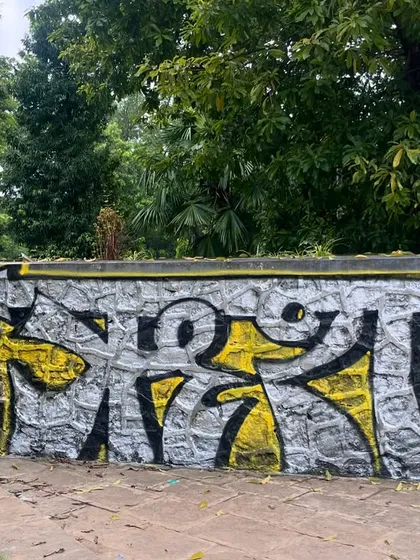 A Devanagari piece on a stone wall. The script flows with the texture of the stones, blending the ancient and the modern.