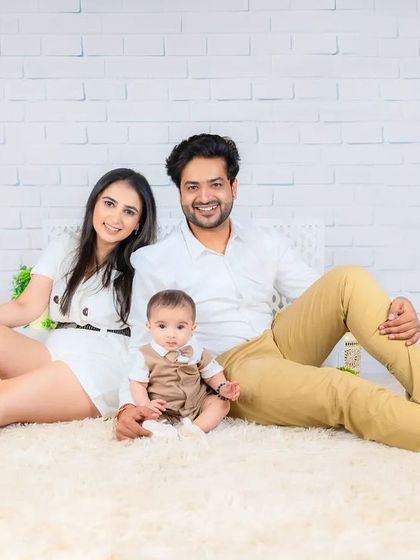 A relaxed and happy family of three, seated on a soft rug. This classic portrait captures a simple, beautiful moment of togetherness.