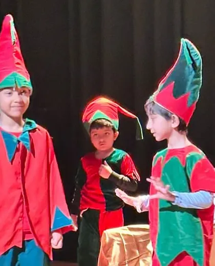 The elves in discussion. This highlights the teamwork and communication skills our students develop while working together in character.
