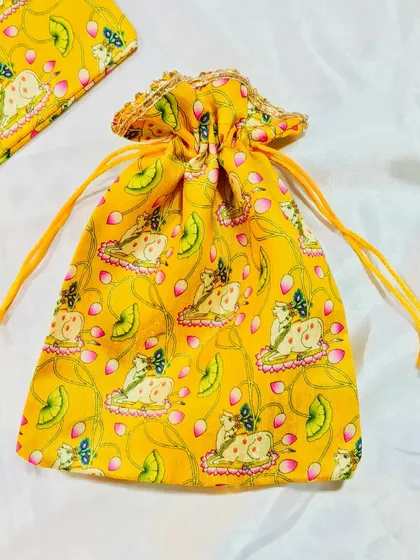 This yellow pichwai-print potli bag adds a touch of traditional art to your gifting. The cow and lotus motif is both beautiful and auspicious.