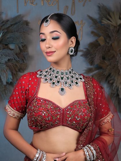 Unveiling bridal elegance that takes your breath away. This look features a clean, sophisticated bun and soft, glowing makeup that complements the diamond and emerald jewelry.