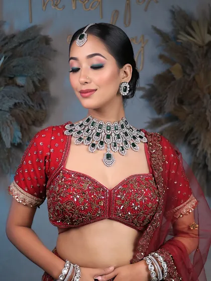 Unveiling bridal elegance that takes your breath away. This look features a clean, sophisticated bun and soft, glowing makeup that complements the diamond and emerald jewelry.