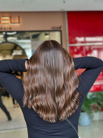 A stunning example of how light reflects off a healthy, well-colored head of hair. The waves accentuate the highs and lows of this brunette balayage.