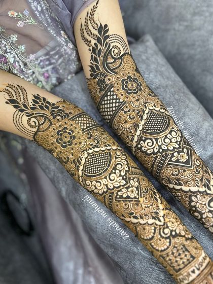 A close up of the upper arms, highlighting the peacock feather inspired motifs.