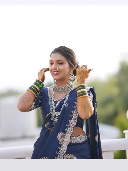 A happy, candid moment showing the bride's complete look, from her makeup and hair to her stunning embroidered Nauvari saree.