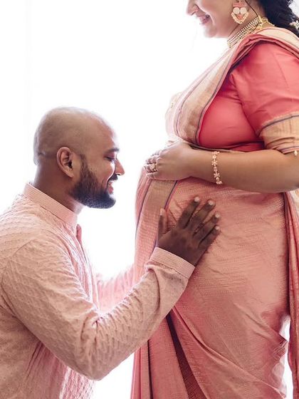 A closer crop of a tender moment. This shot focuses on the partner's loving gaze as he looks at the baby bump, emphasizing the emotional connection.