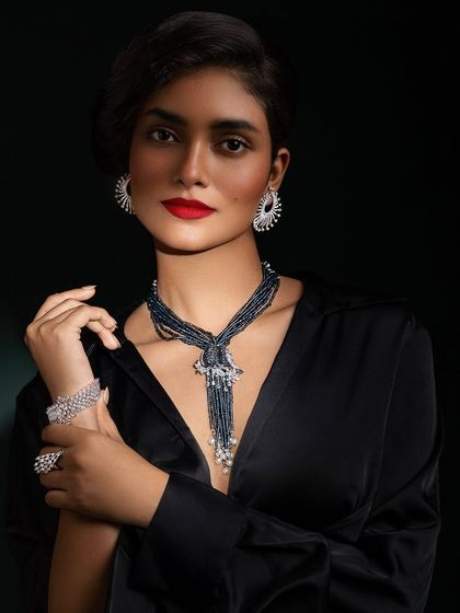 A confident and glamorous portrait, showcasing the complete set of diamond jewelry against the classic black outfit.