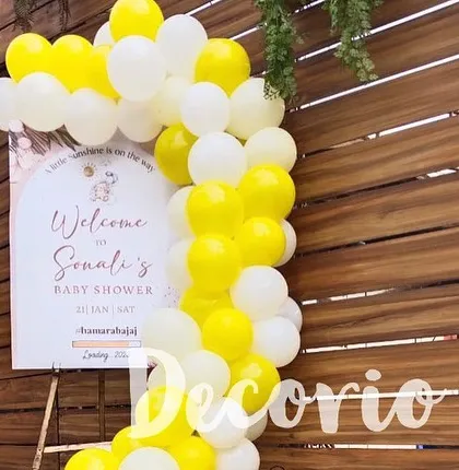 A personalized welcome sign for Sonali's baby shower, framed by a bright yellow and white balloon arch. This is a great way to greet guests as they arrive at the celebration.
