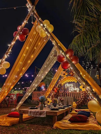 This angle shows how the cabana setup creates a warm and inviting atmosphere at night. The combination of the draped fabric, fairy lights, and surrounding greenery makes it feel like a private little escape.