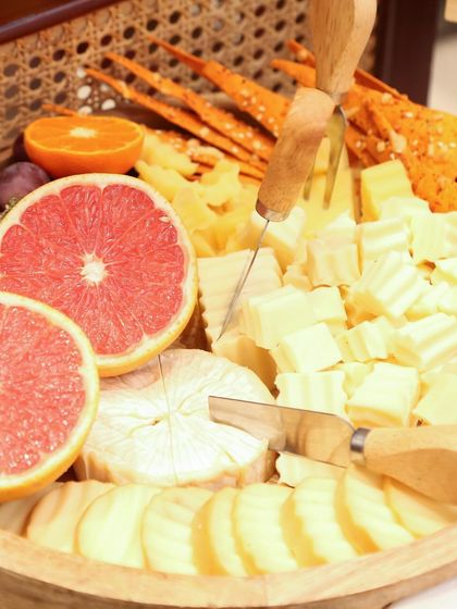 A vibrant cheese board featuring bright pink grapefruit, oranges, and a variety of cheeses. This platter, created for a Guess event, shows how I incorporate fresh, colorful ingredients to make each board pop.