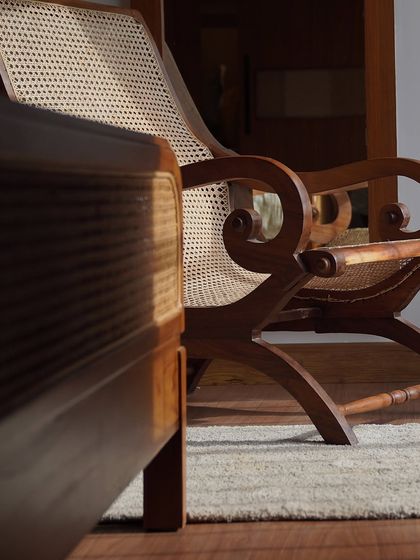 Sunlight catching the details of my classic planter's chair. The scrolled arms and hand-caned seat are a testament to timeless artistry and craftsmanship.