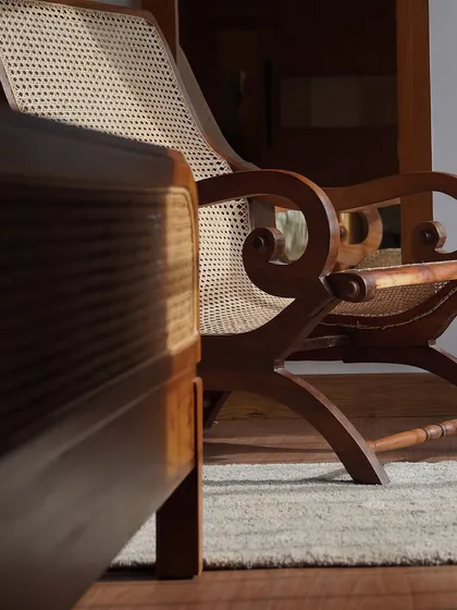 Sunlight catching the details of my classic planter's chair. The scrolled arms and hand-caned seat are a testament to timeless artistry and craftsmanship.