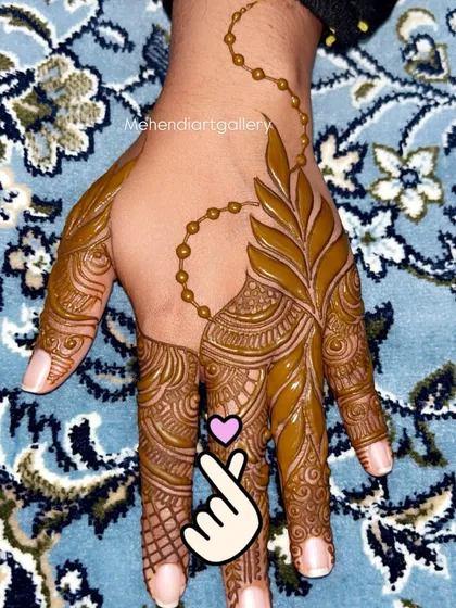 This Gulf-style finger design features intricate details on each finger, connected by a delicate beaded chain. It's a very popular and elegant choice for festive occasions.