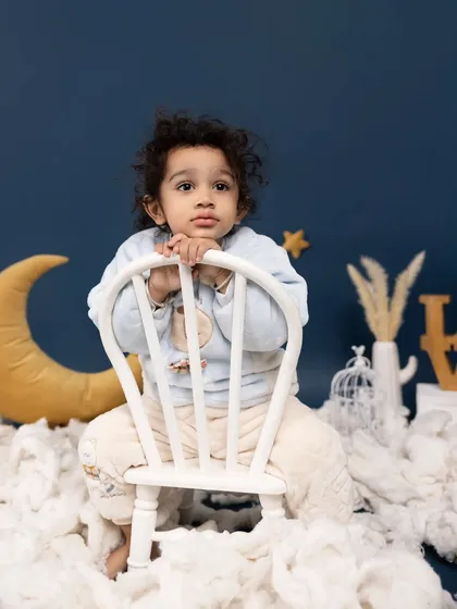 Dreaming among the clouds and stars. Our celestial-themed setup, with a crescent moon and fluffy clouds, provides a serene and magical backdrop for pensive portraits.