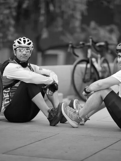 A black and white shot of two members resting. It captures a timeless moment of friendship forged on the road.