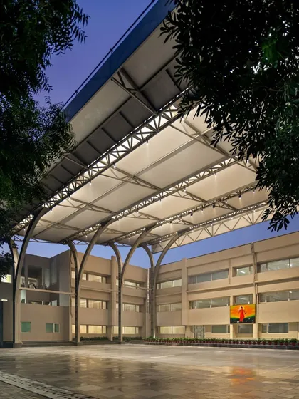 This 12,000 sq ft tensile canopy at SMR Jaipuria School provides an all-weather, climate-responsive solution for outdoor activities. The structure's elegant arches and integrated lighting create a functional and visually striking assembly area, usable day and night, rain or shine.