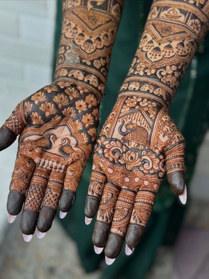 A close-up of a traditional design featuring peacocks and elephants, symbols of grace and strength.