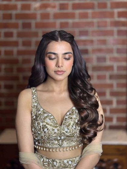 This image showcases the texture and definition of the curls in the twisted half-up style, along with how it complements the client's makeup.