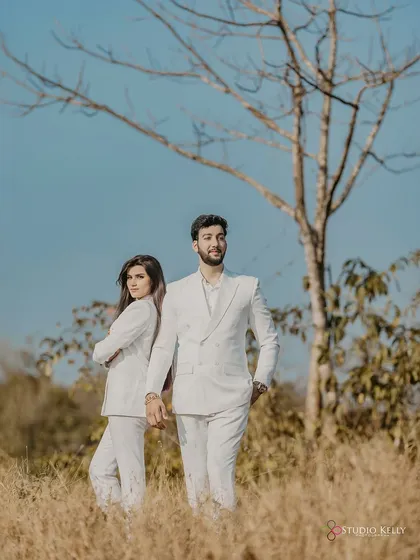 A modern and chic portrait of the couple in matching white suits. The back-to-back pose adds a touch of stylish attitude to their pre-wedding shoot in Goa.