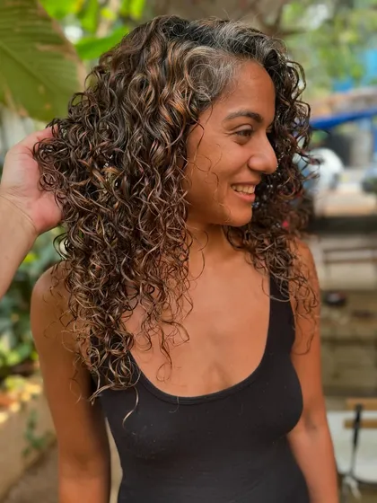 Let your ringlets do the talking. Here I added subtle, non-bleach highlights to enhance the natural curl pattern and blend in some greys.