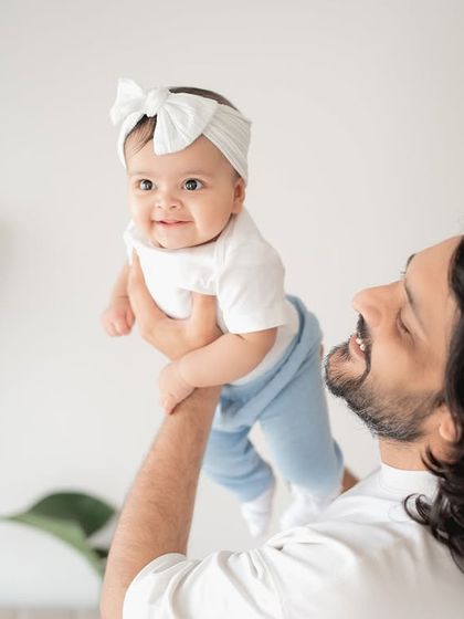 A father lifting his baby girl in the air.