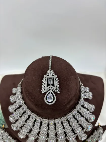 A close-up of the maang tikka from the white AD cascading set.