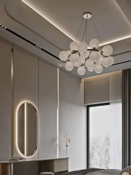 The bedroom's vanity area features a sleek, minimalist desk and an oval backlit mirror, perfect for getting ready in style.