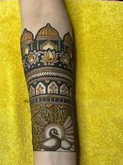 This arm piece combines a palace motif with a beautifully shaded peacock, creating a design that is both royal and graceful.
