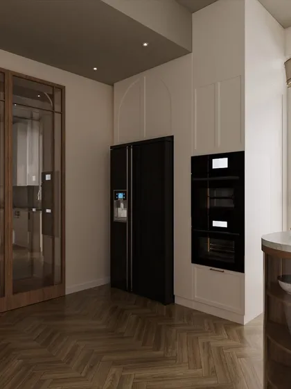 The kitchen design includes integrated appliances for a seamless look. An arch detail frames the built-in ovens, adding a soft architectural touch that connects with other elements in the home.