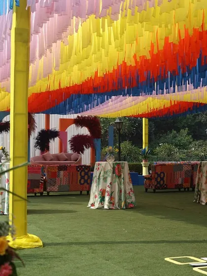 The ceiling decor for a Haldi, made of thousands of colorful ribbons, creating a rainbow effect.