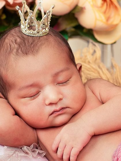 A close-up of a sleeping newborn princess, complete with a tiny crown. These detailed shots capture the delicate features you'll want to remember forever.