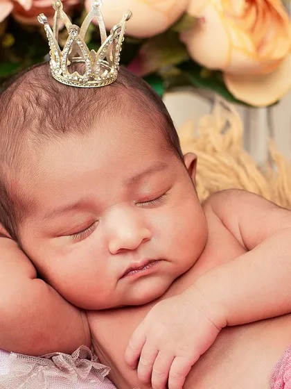 A close-up of a sleeping newborn princess, complete with a tiny crown. These detailed shots capture the delicate features you'll want to remember forever.