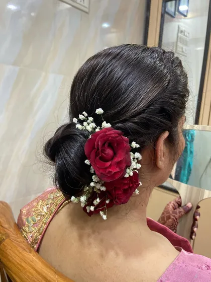 The client admiring her beautiful floral bun in the mirror. It's the perfect finishing touch to her traditional look.