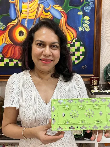 The birthday girl proudly holding the beautiful green Lippan art key holder she created during her surprise 60th birthday party. It's a wonderful keepsake from a special day.