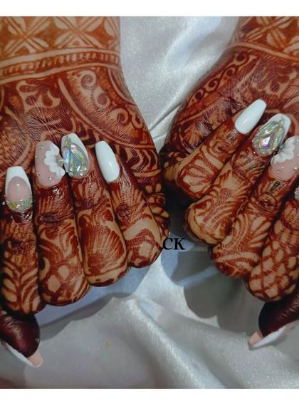 A stunning bridal set featuring long stiletto extensions. The design includes white French tips, solid white nails, and accent nails with holographic diamond stones and 3D floral art.