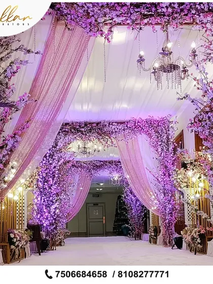 A breathtaking floral entrance tunnel in shades of lavender and pink. This immersive design, complete with chandeliers, makes guests feel like they are stepping into a fairytale.