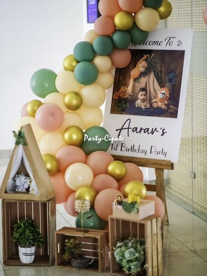 The entrance to Aarav's boho-safari party featured a welcome sign with his photo, a beautiful balloon garland in earthy tones, and rustic wooden crates.