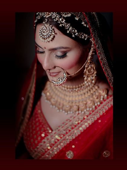 A close-up bridal portrait focusing on the stunning details of the jewelry. The large nath and elaborate necklace are key elements of the traditional bridal look that I love to highlight.