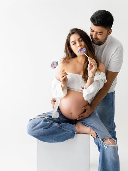 Who says maternity shoots can't be playful? Adding a simple prop like a lollipop brings a sense of fun and personality to the session.