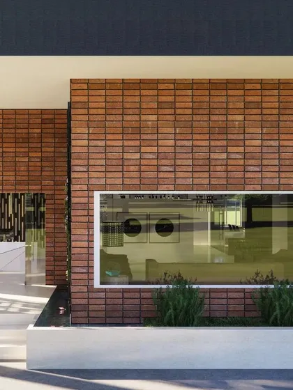 The facade of a marketing office designed to be a future clubhouse. I chose terracotta cladding for a timeless look that will develop a natural patina over time. A large window frames the view of the landscape, bringing the outdoors in and connecting the building to its site.