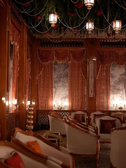 The lounge seating at the reception was designed to feel like intimate royal chambers, with rich wooden pillars, draped curtains, and custom-printed backdrops.